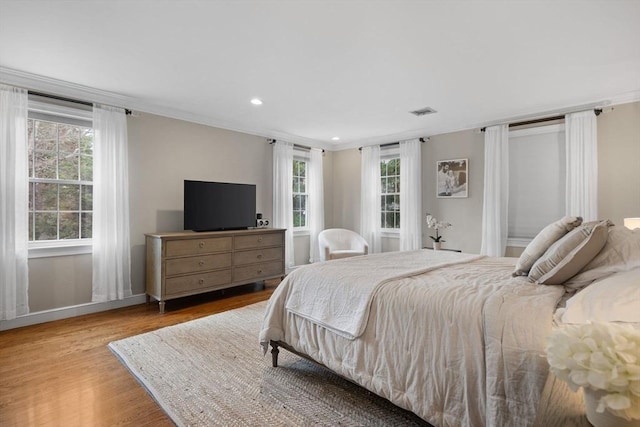 bedroom with recessed lighting, baseboards, multiple windows, and wood finished floors