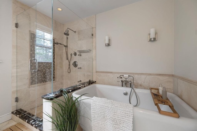 bathroom featuring a shower stall and a bathtub