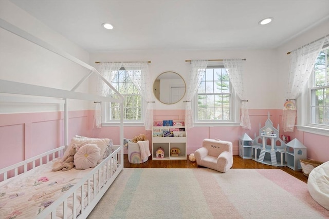 bedroom featuring recessed lighting, wainscoting, and wood finished floors