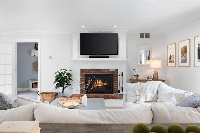 living area with visible vents, crown molding, a fireplace, baseboards, and recessed lighting