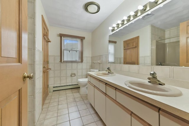 bathroom featuring toilet, tile patterned floors, a sink, and a baseboard radiator