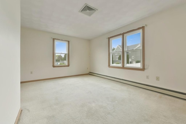 empty room with baseboards, baseboard heating, carpet flooring, and visible vents