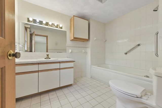 full bathroom with vanity, toilet, tile walls, tile patterned floors, and  shower combination