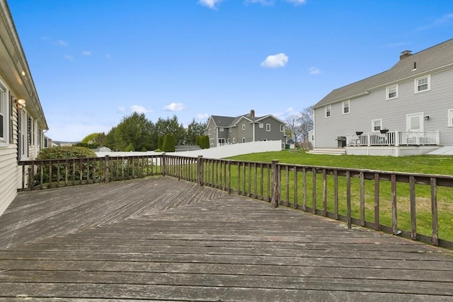 wooden deck with a lawn, fence, and a residential view