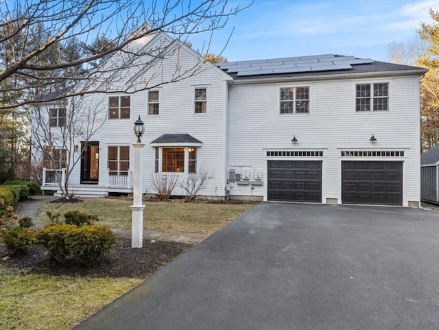 view of front of home featuring solar panels and a garage