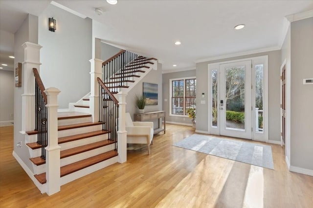 foyer featuring ornamental molding and light hardwood / wood-style flooring