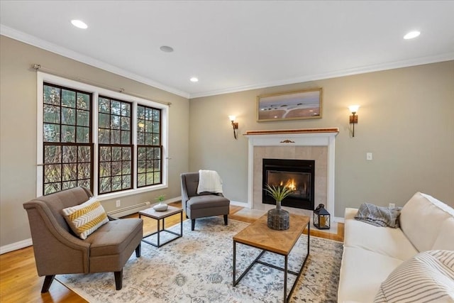 living room with a baseboard radiator, crown molding, and a tiled fireplace