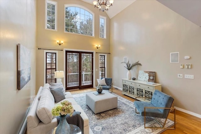 living room with hardwood / wood-style flooring, a high ceiling, and an inviting chandelier