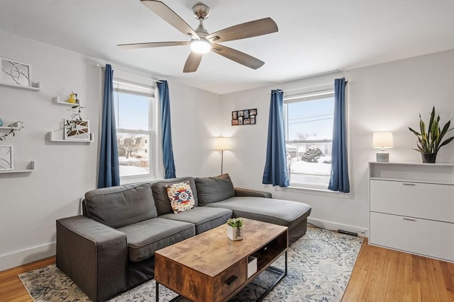 living room featuring plenty of natural light, light wood-style flooring, and baseboards