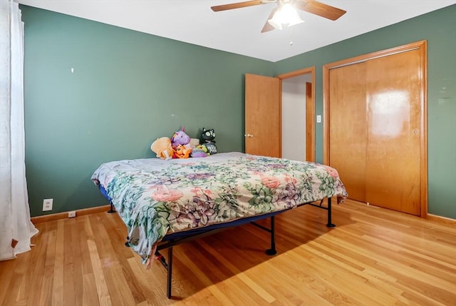 bedroom with hardwood / wood-style floors, ceiling fan, and a closet