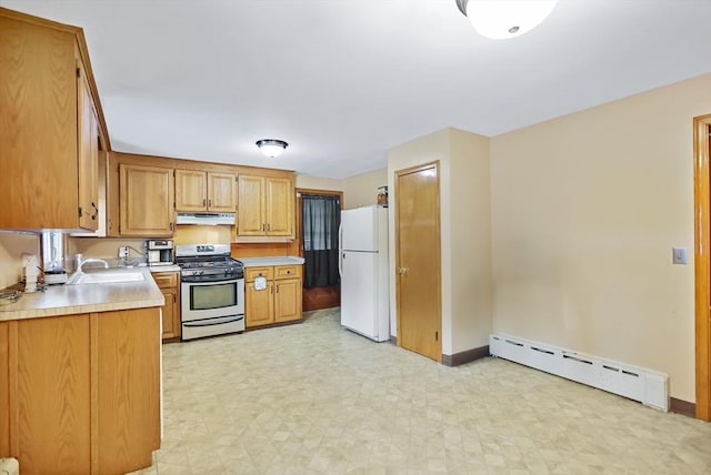 kitchen with a baseboard heating unit, sink, stainless steel range with gas stovetop, and white refrigerator