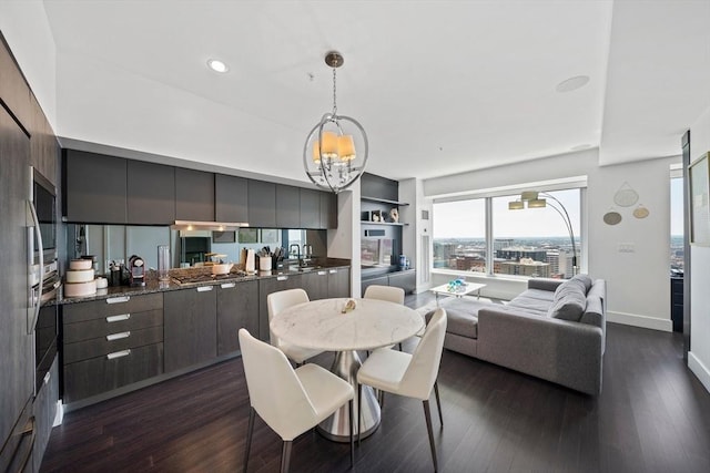 dining room with built in features, sink, dark hardwood / wood-style floors, and an inviting chandelier