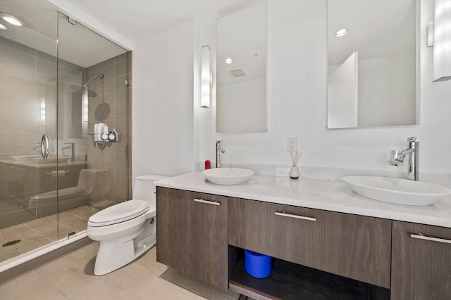 bathroom with tile patterned flooring, vanity, toilet, and a shower with door