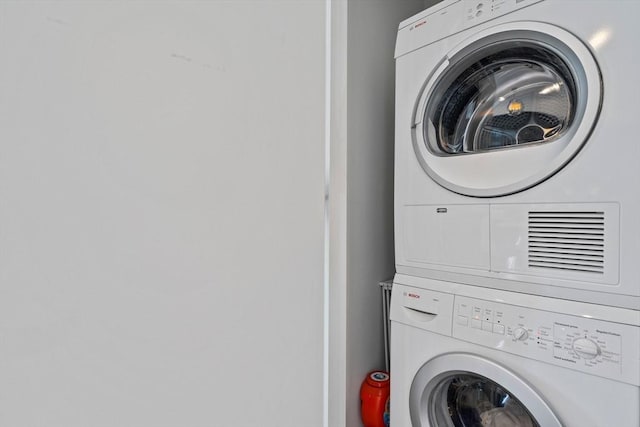 clothes washing area featuring stacked washing maching and dryer