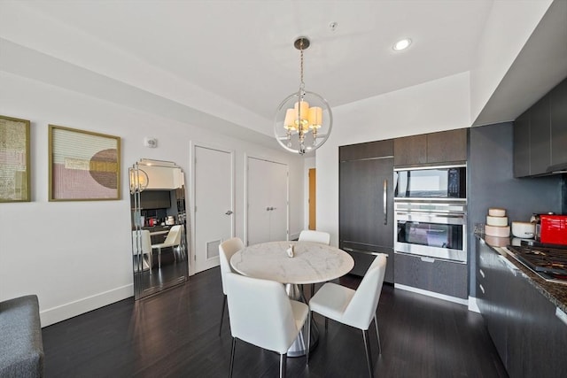 dining area with a notable chandelier and dark hardwood / wood-style floors