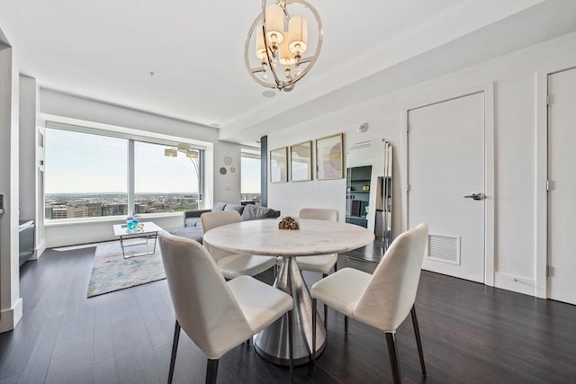 dining space with dark hardwood / wood-style floors and a notable chandelier