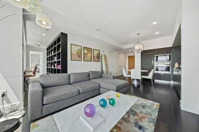 living room with dark hardwood / wood-style flooring and an inviting chandelier