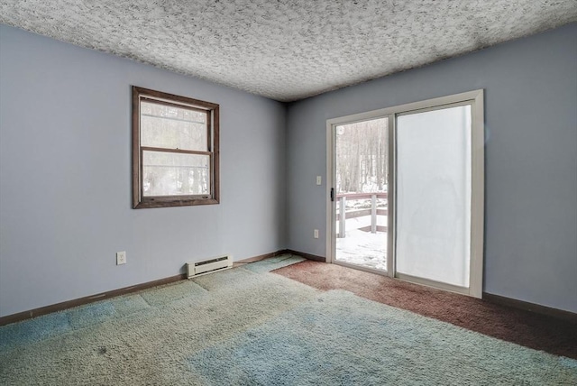 empty room featuring baseboard heating, carpet flooring, a textured ceiling, and a wealth of natural light