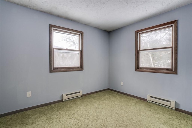 carpeted empty room featuring baseboard heating and a textured ceiling