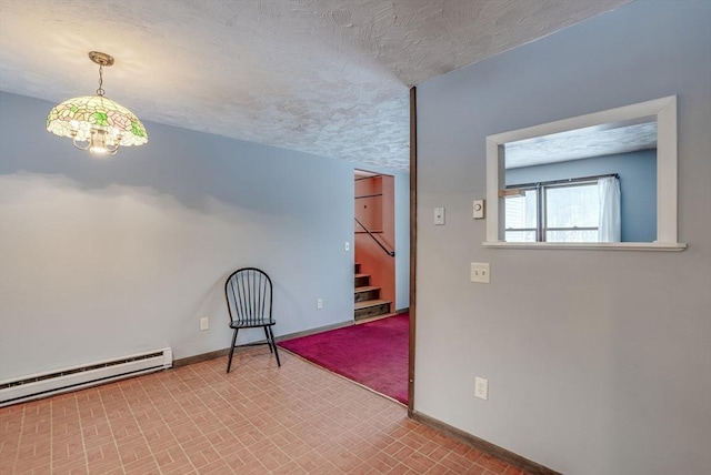 unfurnished room with a textured ceiling and a baseboard heating unit