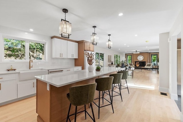 122 Charles St, Reading, MA 01867 - kitchen with a sink, a kitchen island, recessed lighting, light wood-type flooring, and backsplash