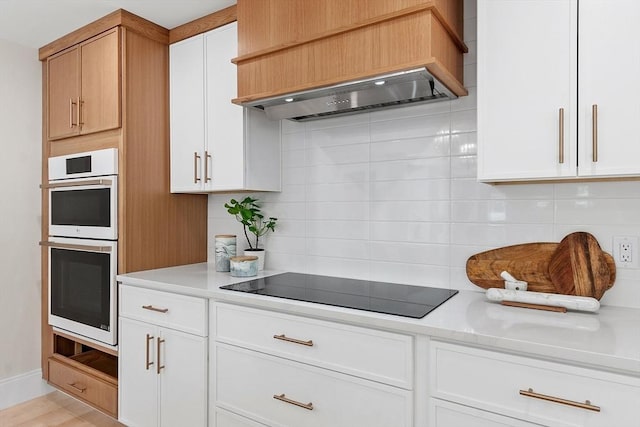 122 Charles St, Reading, MA 01867 - kitchen featuring custom range hood, decorative backsplash, light countertops, and double oven