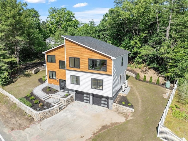 122 Charles St, Reading, MA 01867 - contemporary house featuring an attached garage, driveway, and roof with shingles