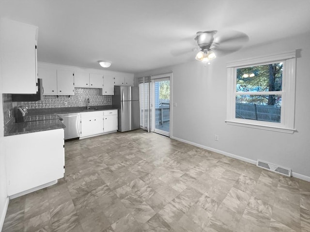 kitchen with stainless steel appliances, white cabinets, ceiling fan, decorative backsplash, and sink