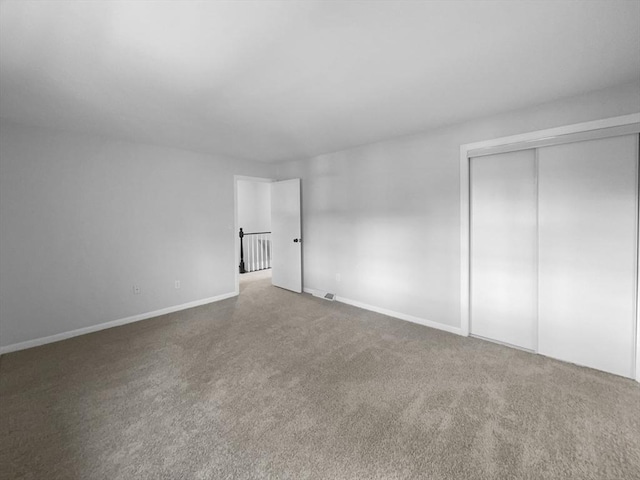 unfurnished bedroom featuring carpet flooring and a closet