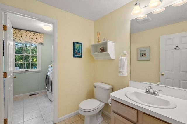 bathroom featuring tile patterned flooring, vanity, toilet, washer / clothes dryer, and baseboards