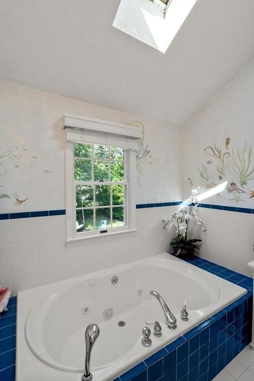 bathroom featuring a whirlpool tub, a skylight, and tile walls