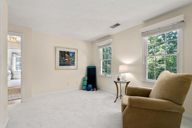 living area featuring visible vents, carpet, and baseboards