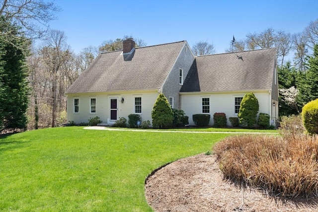 view of front of home with a shingled roof, a chimney, and a front yard