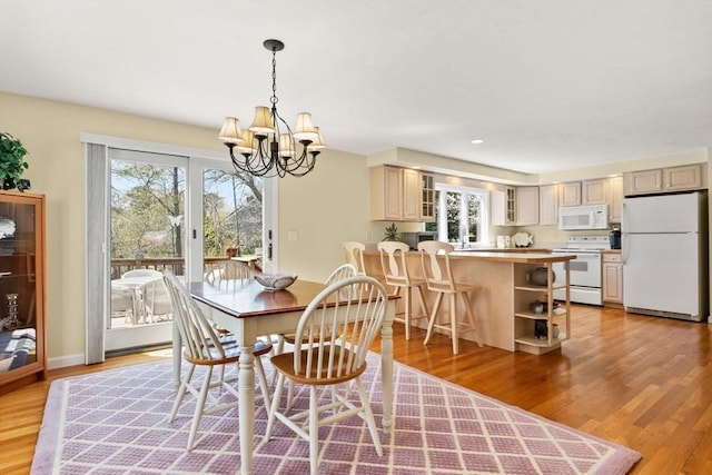 dining area with plenty of natural light, light wood-style flooring, and an inviting chandelier