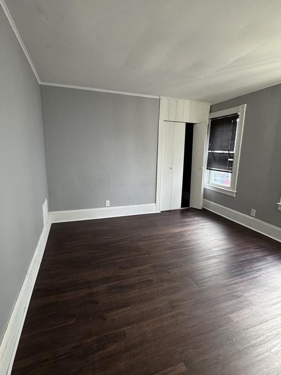 unfurnished bedroom featuring ornamental molding and dark hardwood / wood-style floors