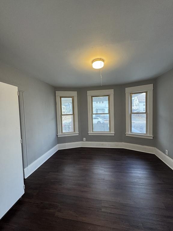 spare room with dark hardwood / wood-style flooring