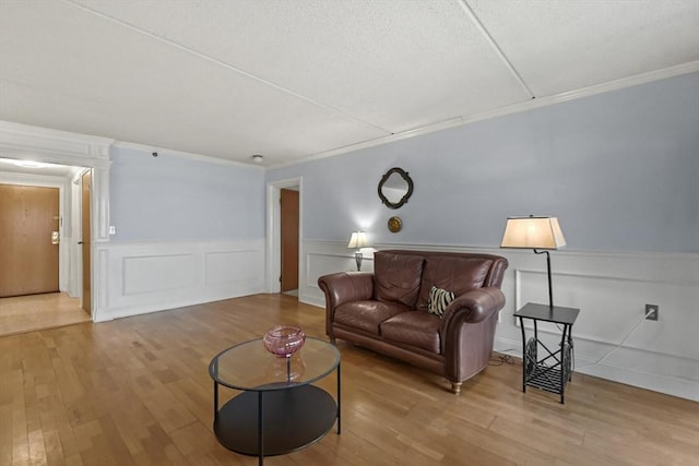 living room featuring light wood-type flooring and ornamental molding