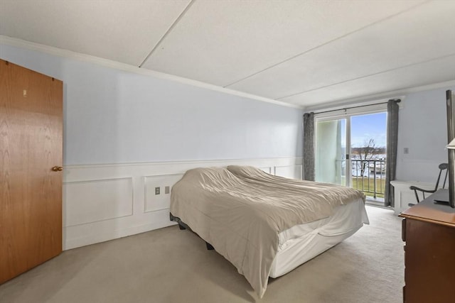 bedroom featuring ornamental molding, access to outside, and light colored carpet