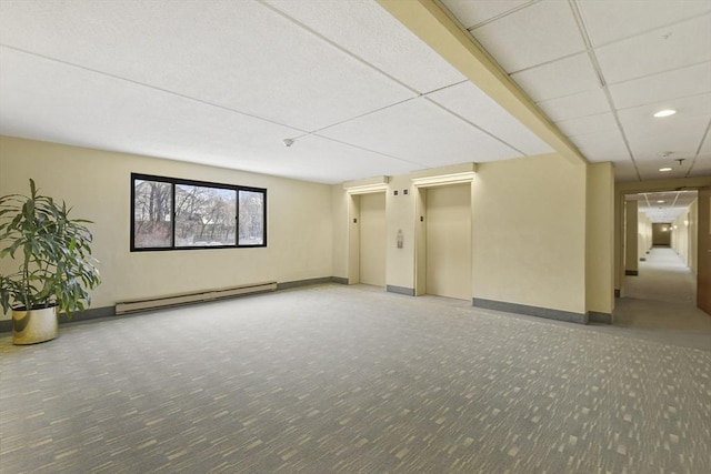 interior space with a paneled ceiling and baseboard heating