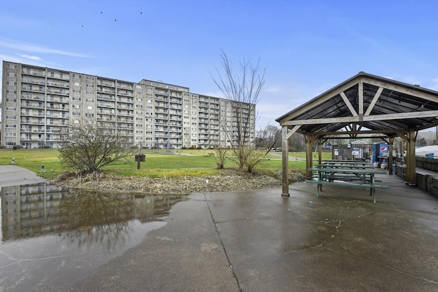 exterior space featuring a gazebo, a water view, and a lawn