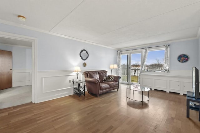 sitting room with hardwood / wood-style flooring and ornamental molding