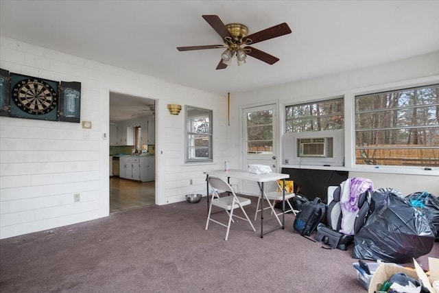 sunroom with ceiling fan and a wall mounted air conditioner