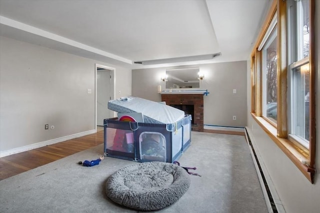 interior space with carpet, a fireplace, and a baseboard heating unit