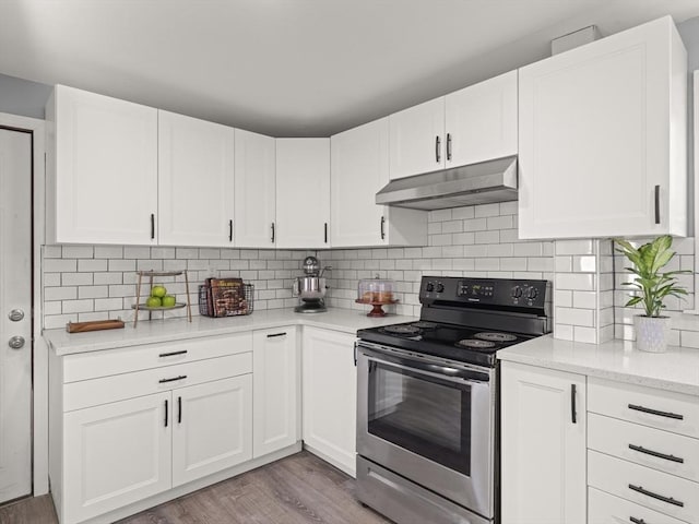 kitchen featuring white cabinets, electric stove, and tasteful backsplash