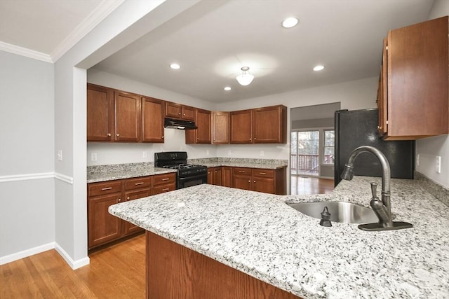 kitchen with kitchen peninsula, light stone countertops, crown molding, black range with gas stovetop, and sink