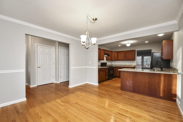 kitchen with sink, kitchen peninsula, hanging light fixtures, gas range, and crown molding