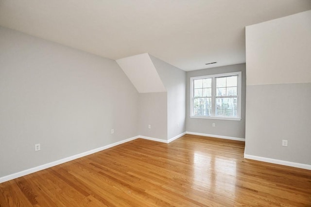 bonus room with light hardwood / wood-style flooring and vaulted ceiling