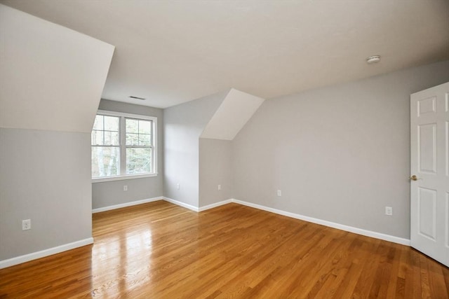 bonus room with hardwood / wood-style floors and lofted ceiling