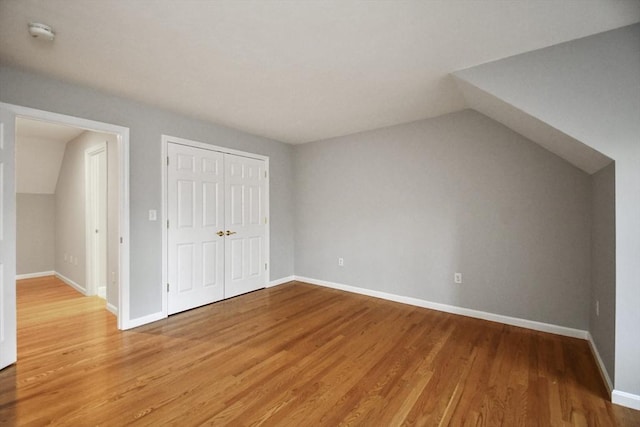 additional living space with lofted ceiling and hardwood / wood-style floors