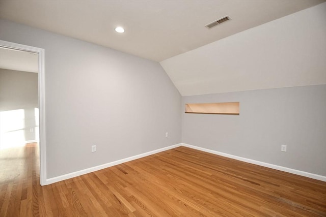 bonus room with lofted ceiling and hardwood / wood-style flooring